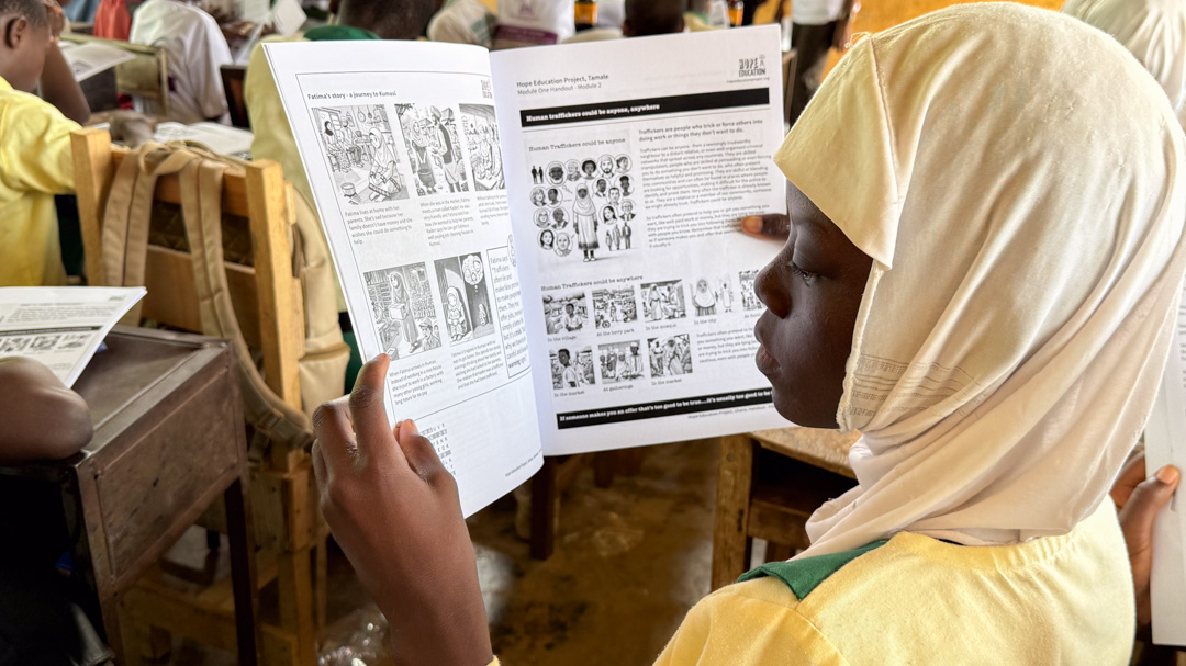 A young student reads the Hope Education Project Schools handout containing cartoons and stories and word games associated with the Human Trafficking Education Program.